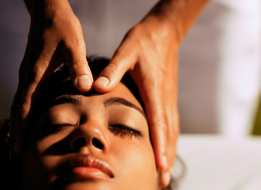 san diego massage therapist massages womans face between the eyebrows